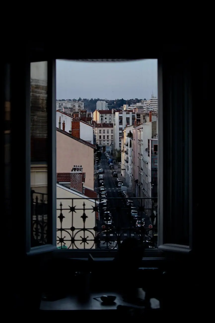 Fenêtre ouverte sur rue de la ville, contraste de la ville éclairée avec la pièce sombre.